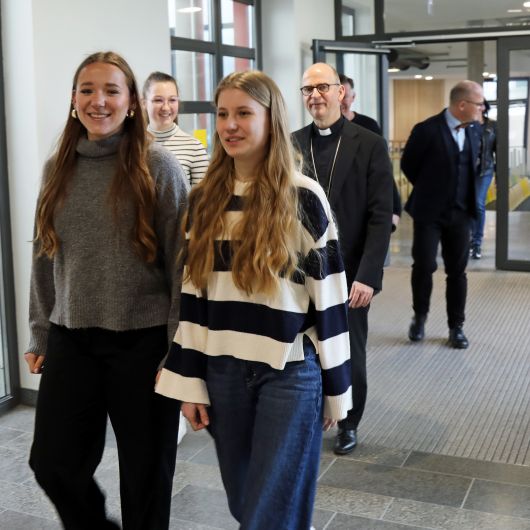 Die Schülersprecherinnen Ella Krafft, Mia-Maria Keßler (vorne) und Melina Roscher führen Bischof Dr. Franz Jung durch die Schule.