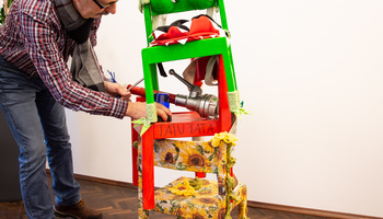Peter Kobert legt nach Anlieferung des Kunstwerks im Caritashaus letzte Hand an die "Stuhl-Skulptur". 