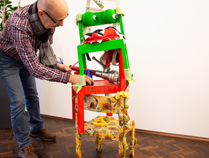 Peter Kobert legt nach Anlieferung des Kunstwerks im Caritashaus letzte Hand an die "Stuhl-Skulptur". 