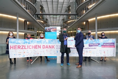 Der Vorsitzende des Petitionsausschusses des Deutschen Bundestages, Marian Wend, nimmt die 53.000 Unterschriften der Petition "Mehr wert als ein Danke" entgegen.