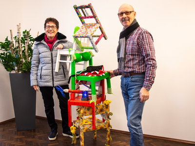 Sieglinde und Peter Kobert überbringen das Kunstwerk des Kindergartens Villa Kunterbunt in Karlstein für den Kreativwettbewerb zum 100. Jubiläum des Diözesan-Caritasverbands.