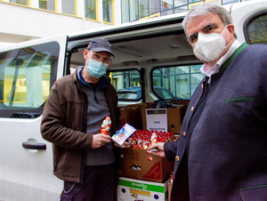 Der Vorsitzende des Diözesan-Caritasverbands, Clemens Bieber (r.), und Hausmeister Alfred Krafft neben am Caritashaus die Schokoladenspende der Edeka Frischemärkte Trabold entgegen.