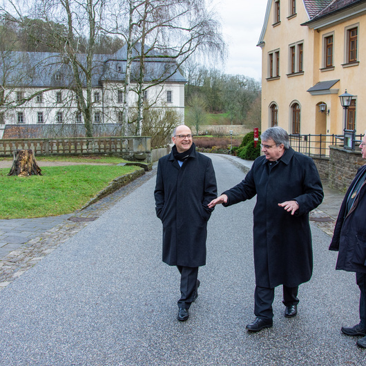 Der Caritasvorsitzende, Domkapitular Clemens Bieber (Mitte), und Einrichtungsseelsorger P. Gottfried Scheer (rechts) begleiten Bischof Franz Jung beim Gang über das Klostergelände.