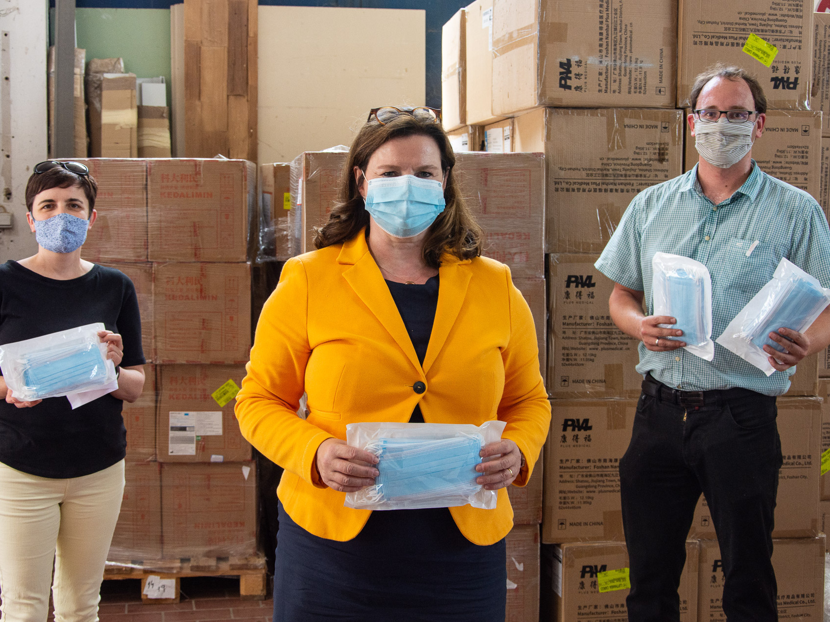 Abteilungsleiterin Sonja Schwab (v.l.), Caritasdirektorin Pia Theresia Franke und Fachbereichsleiter Kilian Bundschuh nehmen die Spende von knapp 400.000 Mund-Nasen-Masken entgegen.