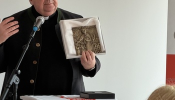 Domkapitular Clemens Bieber überreicht der Tagespflege in Volkach ein Bronzebild.